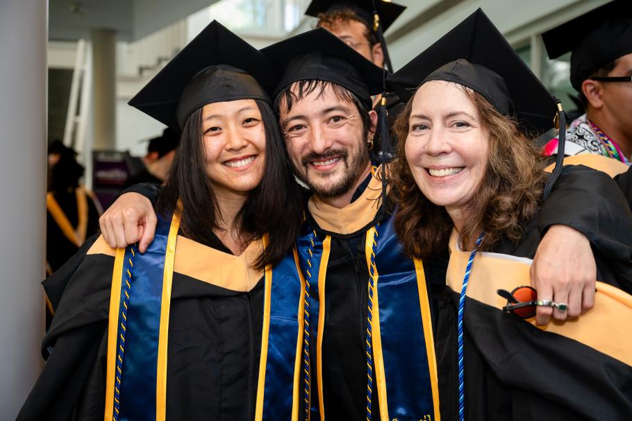 Three graduates from the class of 2025 pose in their caps and gowns.