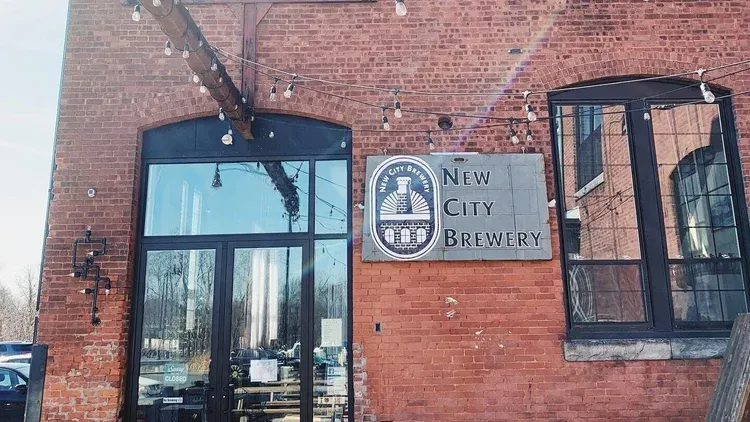 new city brewery sign on brick building wall with glass doors