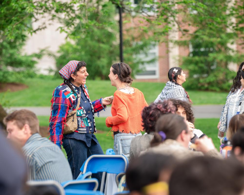 Two students laugh and reconnect during the 2025 opening ceremony.