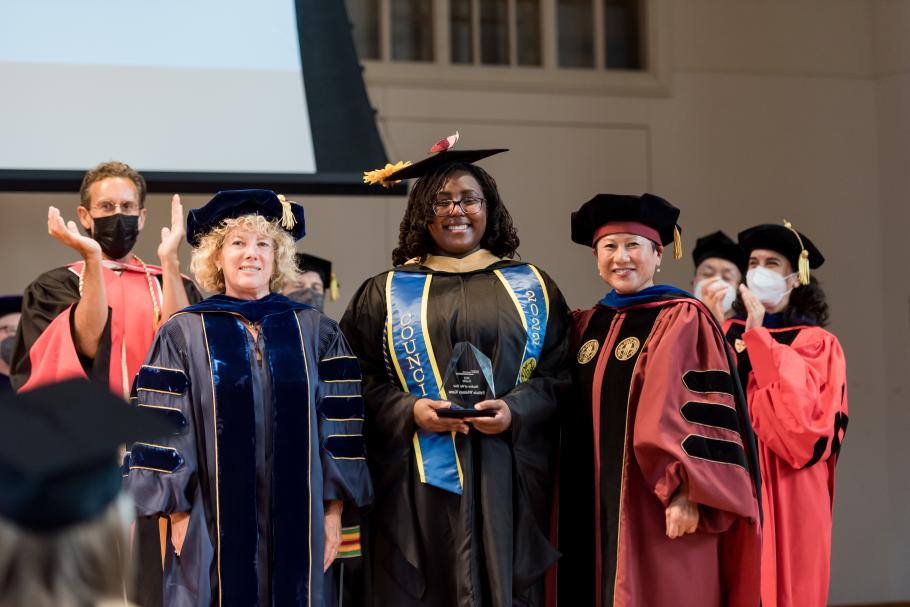 Faculty posing with NASW (National Association of Social Workers) student of the year, Felicia Kanu at commencement