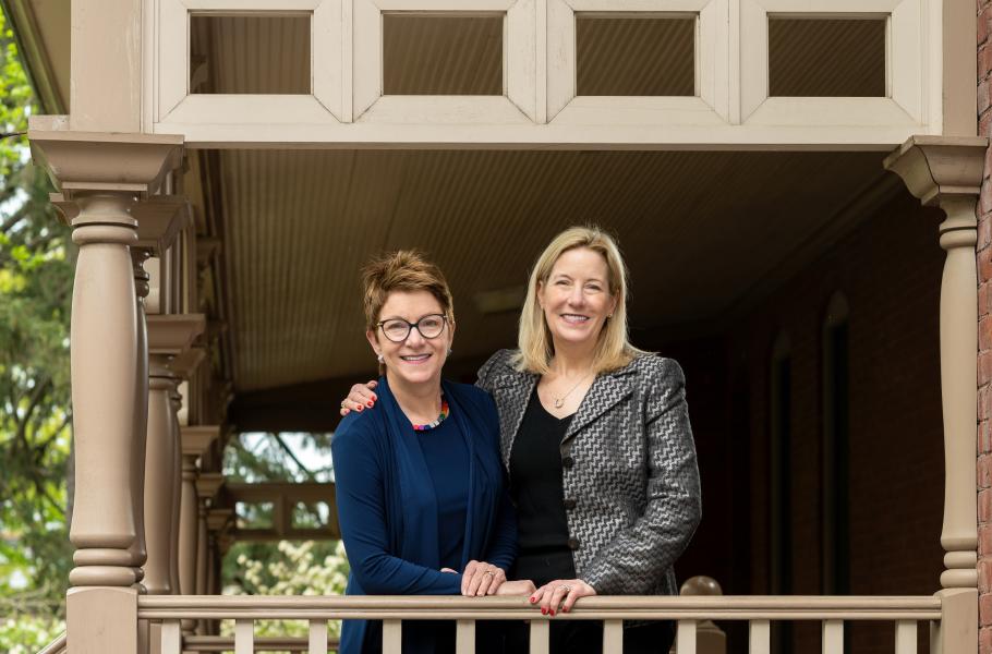 Jenny Johnson and Christina Higgins stand on a covered porch at Smith College.