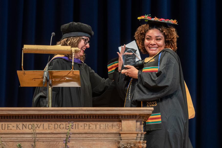 Chynna Aming smiles at the crowd holding the NASW Student of the Year Award