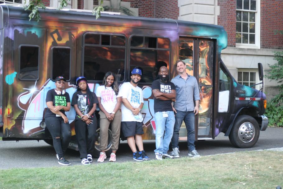 John Gill (far right) poses with the team from Children's Services of Roxbury outside the mobile Beats, Rhymes, Life recording studio. Photo by Simone Stemper. 