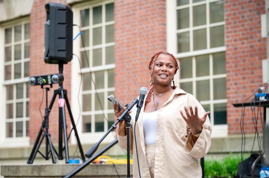 Resident faculty JaLisa Williams speaking at a microphone