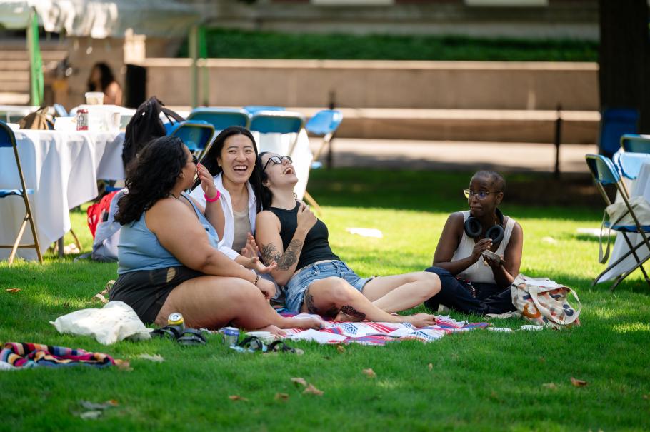 Four students sitting on a blanket together