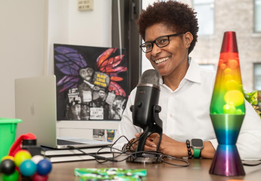 JD Fuller sits behind her podcast mic in her office.