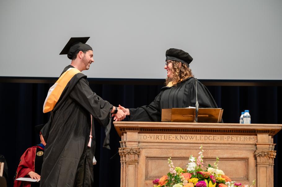 2024 NASW Student of the Year Rian Bodner shakes Associate Dean Megan Harding's hand