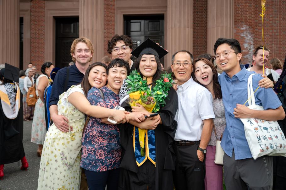 A 2024 M.S.W. graduate poses with their family after commencement. 