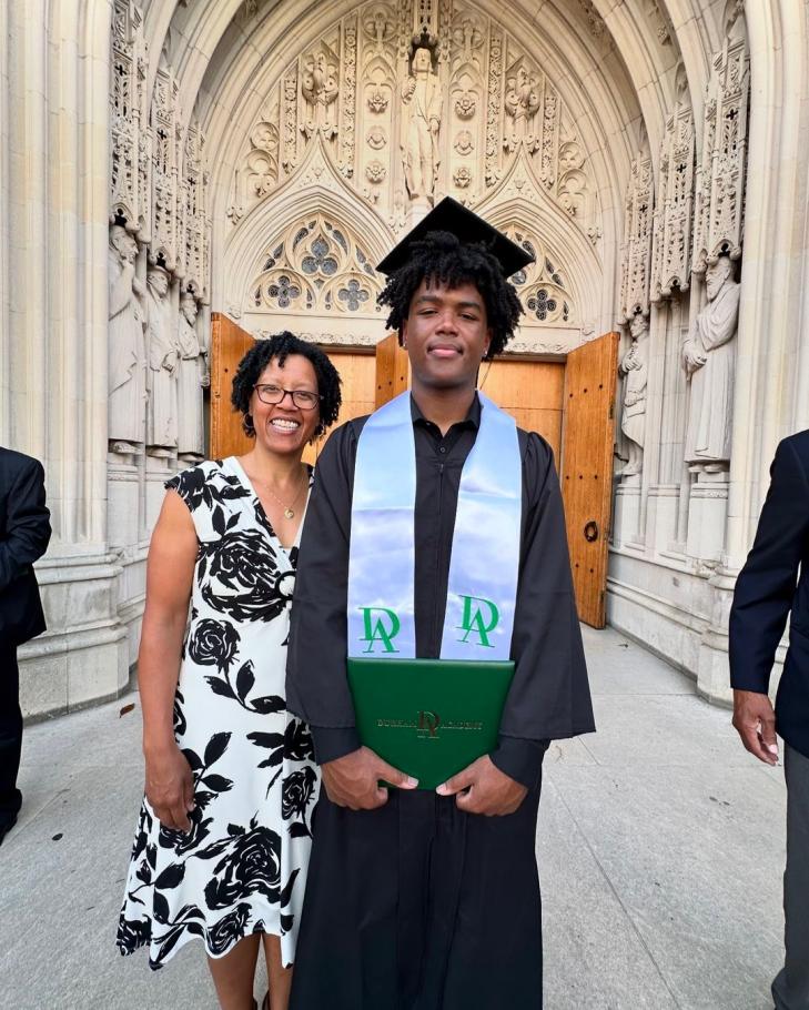 Jennifer Ashby Bullock stands with her son at his graduation in front of grey stonework cathedral entryway