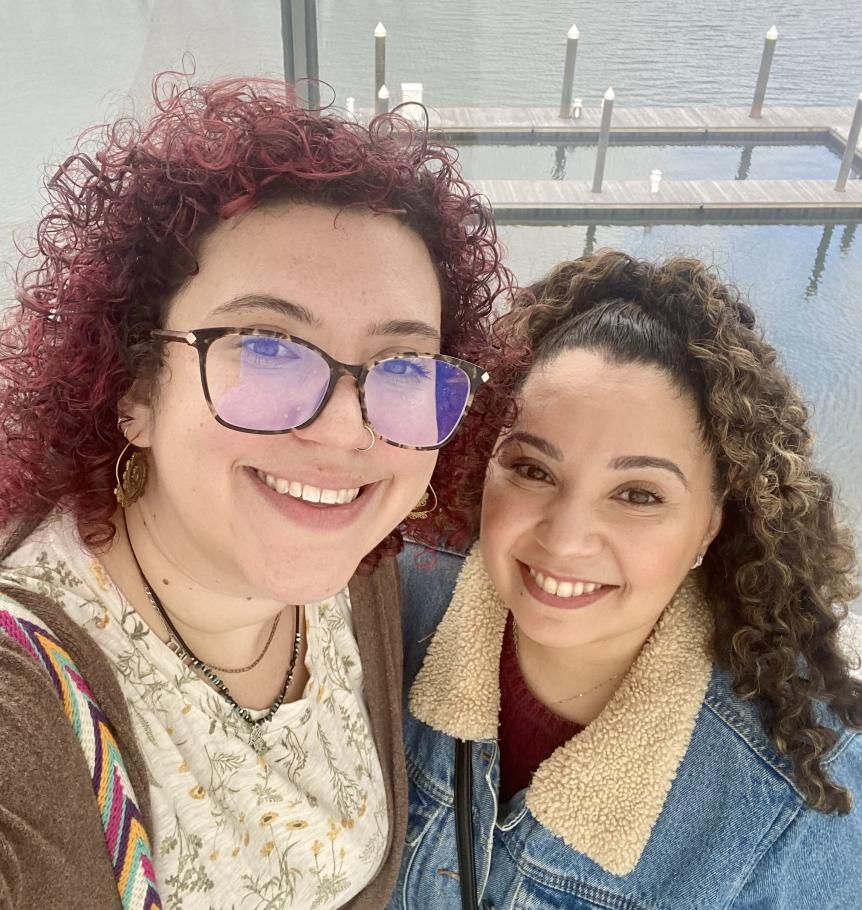 Hannah Biskind and friend take a selfie with a small pier and water in the background