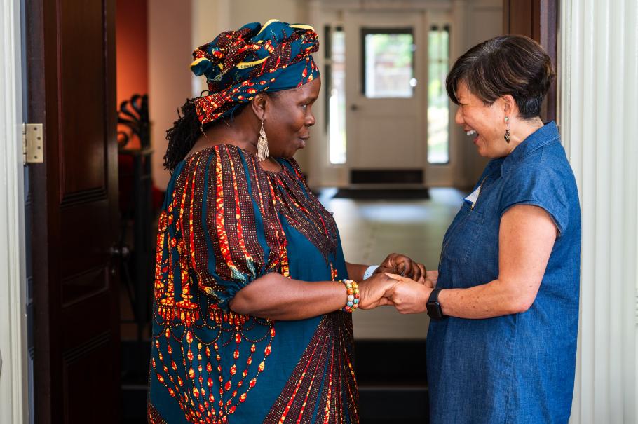 Marianne Yoshioka clasps both hands laughing with Adama Sallu