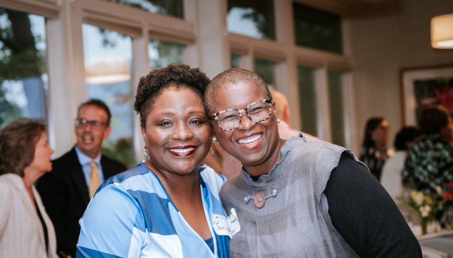 Tanita Teagle and Lisa Moore smiling together with people in background during the 2025 Alumni Awards