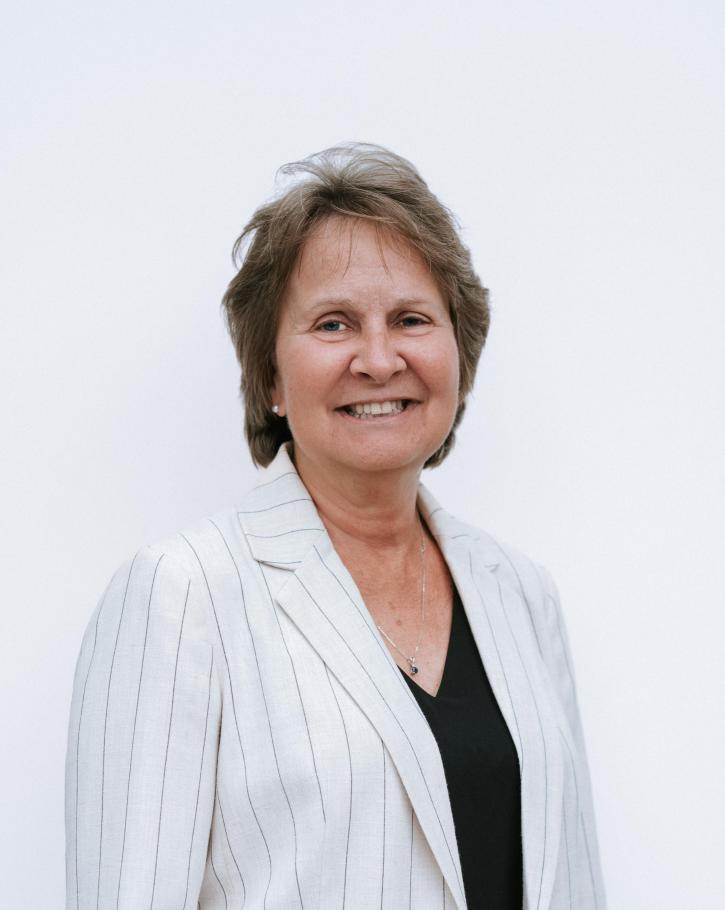 Portrait of Cathleen Morey wearing white blazer with pinstripes against white background