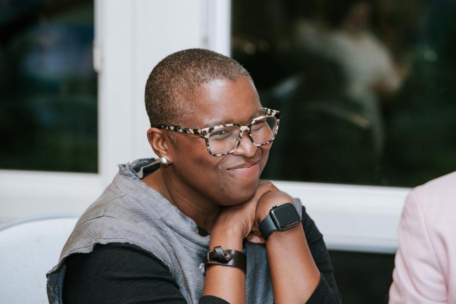 Lisa Moore sitting with hands clasped under her chin with windows behind