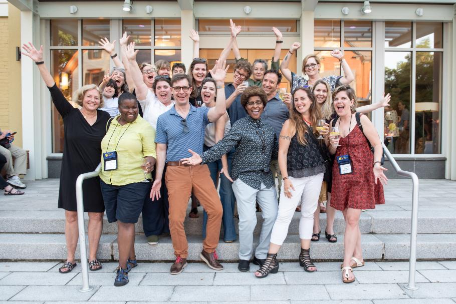 a group of 20 alums smiling, arms raised outside the Smith College Conference Center during the 2018 Centennial celebration