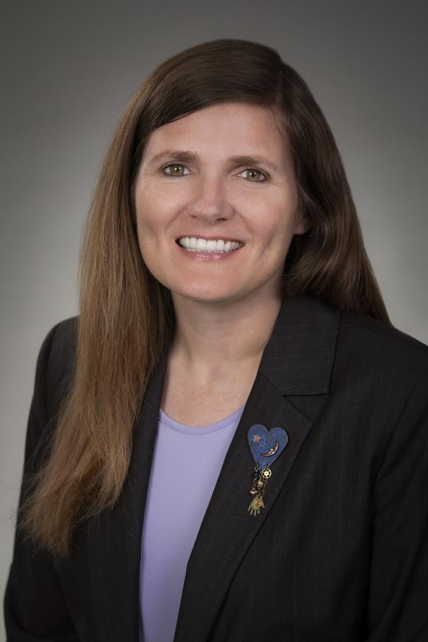 Samantha Mishne wearing dark blazer and lavender shirt