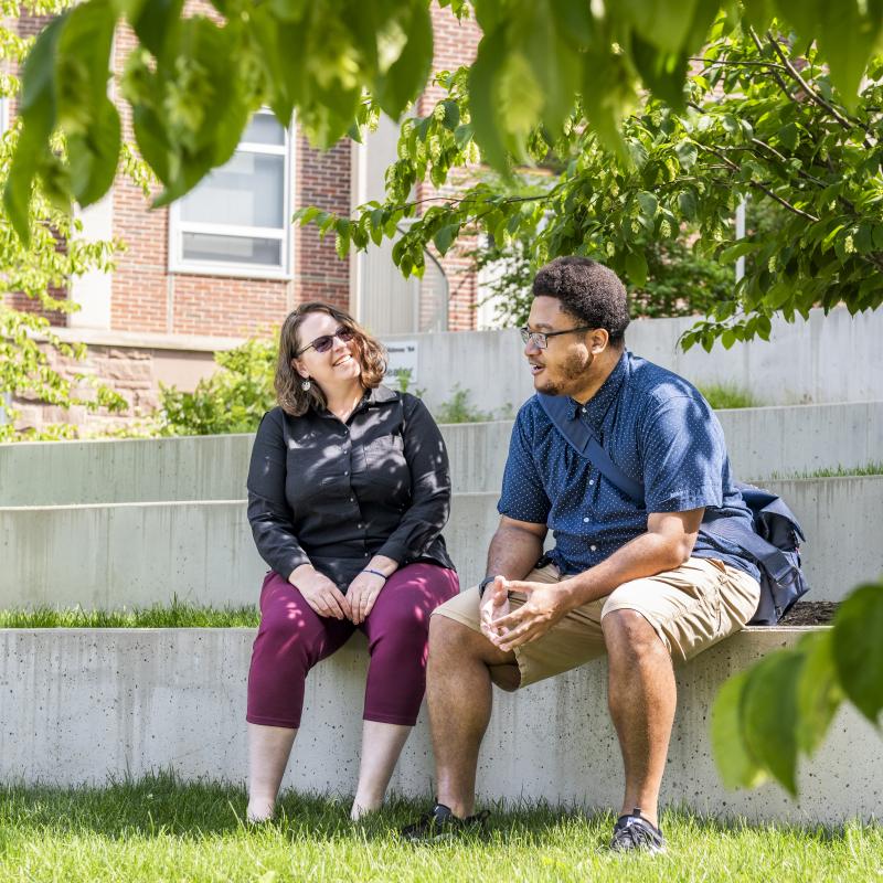 A student sits outside with their practicum supervisor.