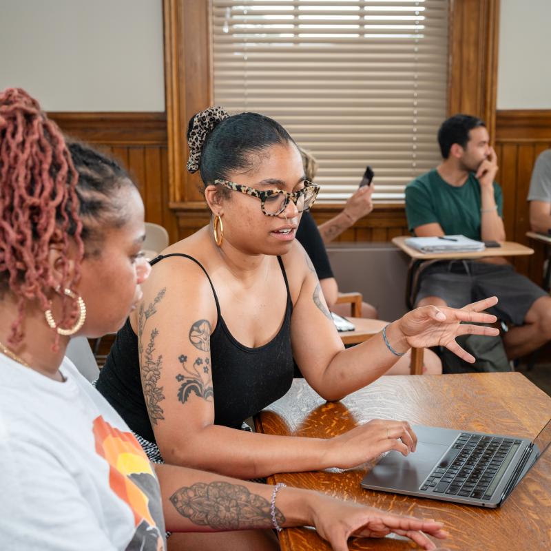 A student and teacher engage in deep conversation during class time.