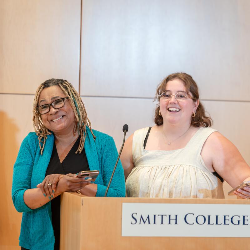 Two people at a podium smiling
