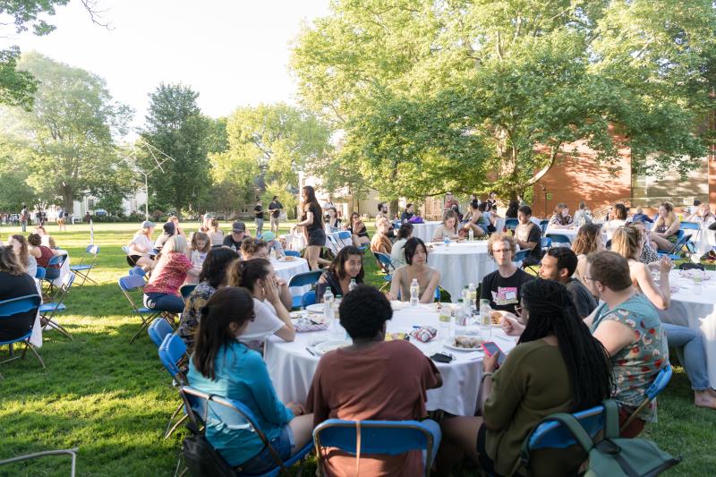 Students sit at tables on Seelye Lawn during the opening ceremony and dinner in 2022. 