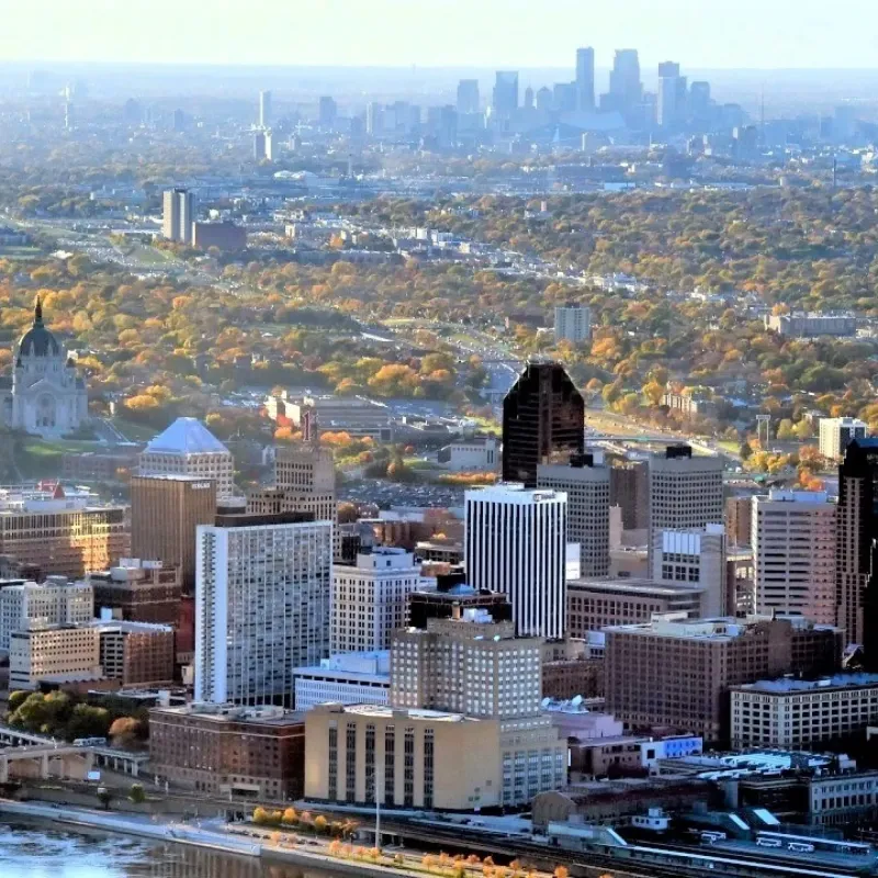 Aerial view of the twin cities, Minneapolis and Saint Paul. A little water in the foreground, skyscrapers, trees visible in distance