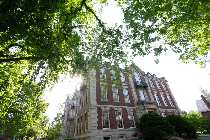 Seelye Hall, a brick building with cement blocks, green leaves