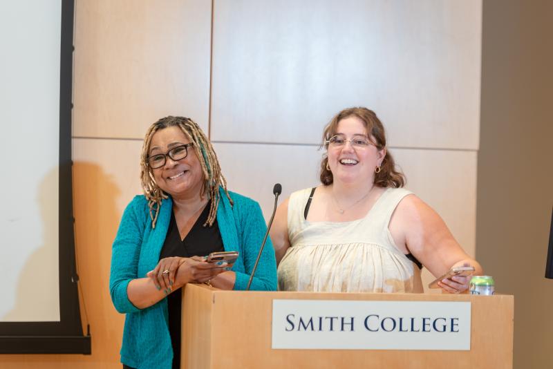 Two people at a podium smiling