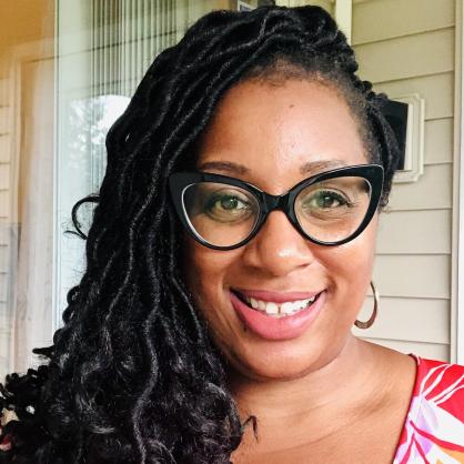 LaTasha Smith smiles at the camera wearing a red and white patterned shirt.