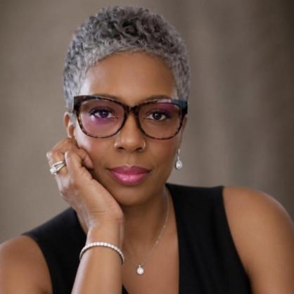 Julie Clockston portrait wearing glasses, hand on chin