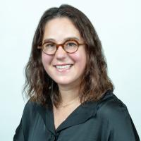 Naomi Gofine wearing black shirt and brown glasses smiling