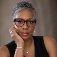 Julie Clockston portrait wearing glasses, hand on chin