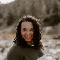 Rebecca Davis stands outside with rocks and trees behind