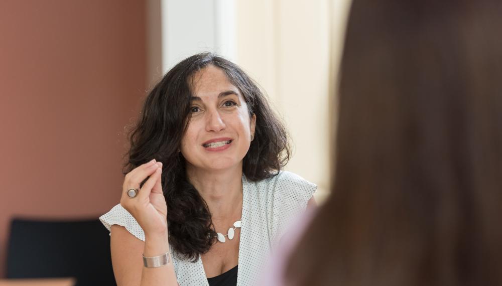 Ora Nakash gestures with her hands as she speaks with Ph.D. students.