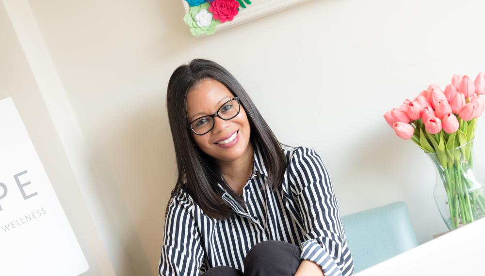 Cheryl Aguilar wearing a striped shirt sitting in an office