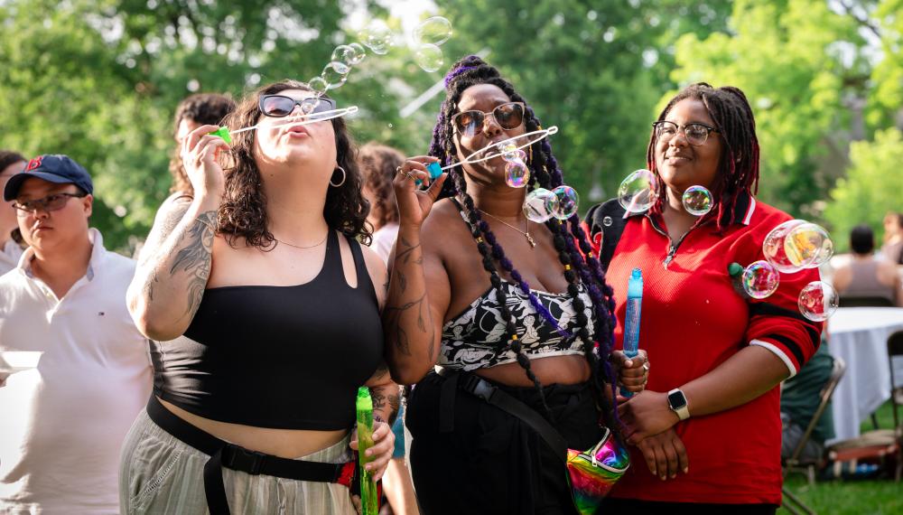 Three students blow bubbles on Seelye Lawn