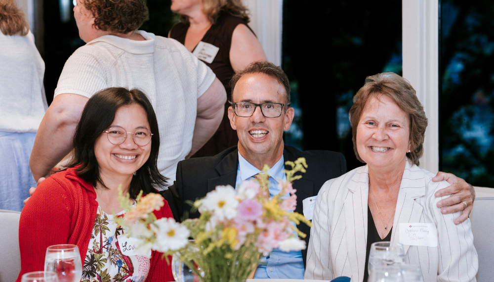 Cathleen Morey (R) sits with her husband and fellow alum Loan Vo at the 2025 Alumni Awards