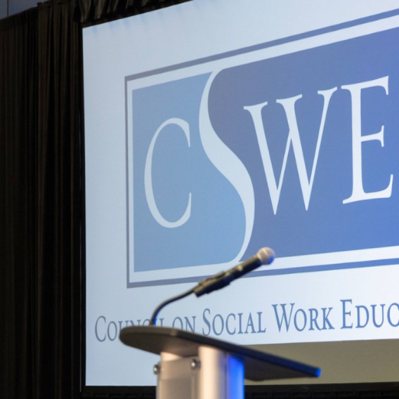 A mic and podium in front of a screen that reads CSWE Council on Social Work Education