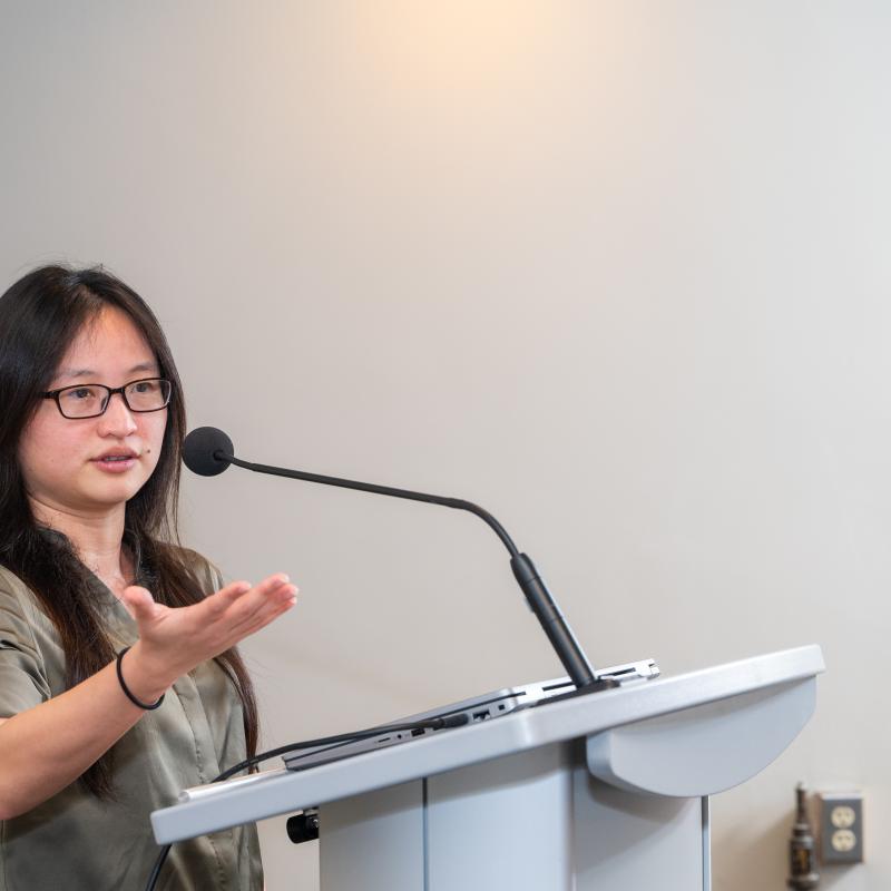 Helen Chao speaking behind a podium with mic 