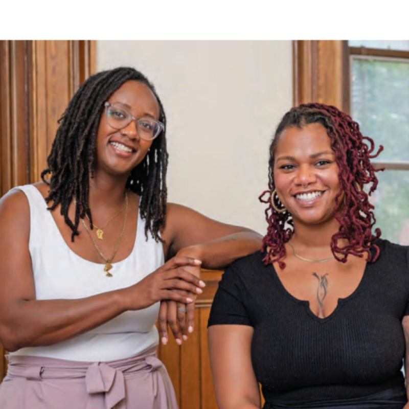 Janae Peters and JaLisa Williams standing together inside a classroom with windows behind