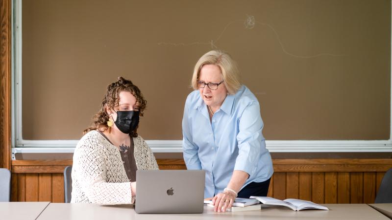 A student works with a faculty member during class.
