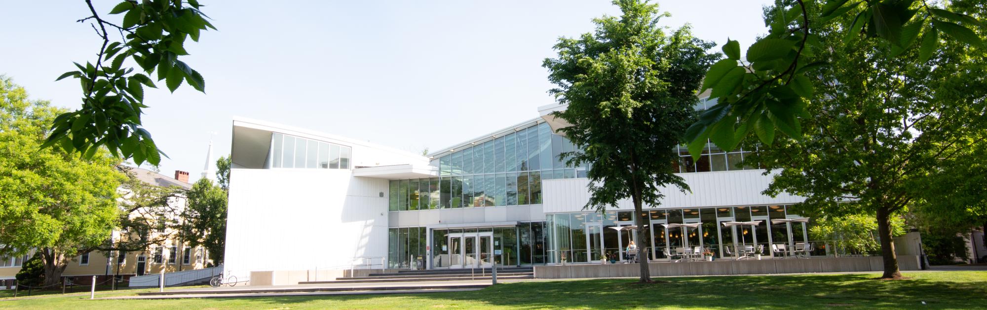 The Smith College Campus center is viewed from a distance, with tree branches in the foreground. 